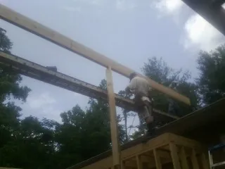 Carpenter setting a ridge beam over a new addition frame — Ice Dam Removal by Roofing Brothers in Suisun City