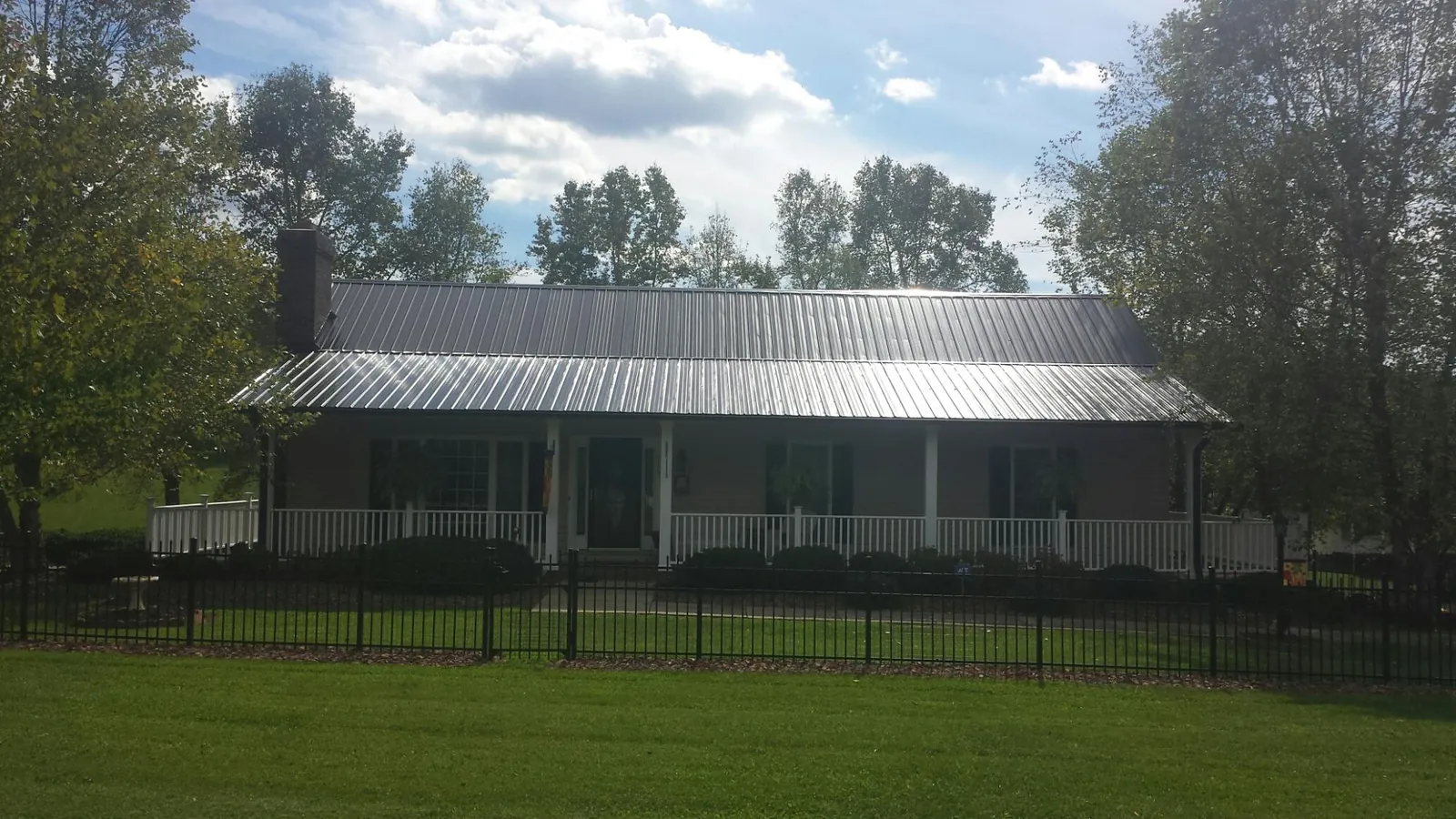 Gray metal roof on a brick ranch with a full width front porch — Gutter Guard Installation work by our crew in Suisun City