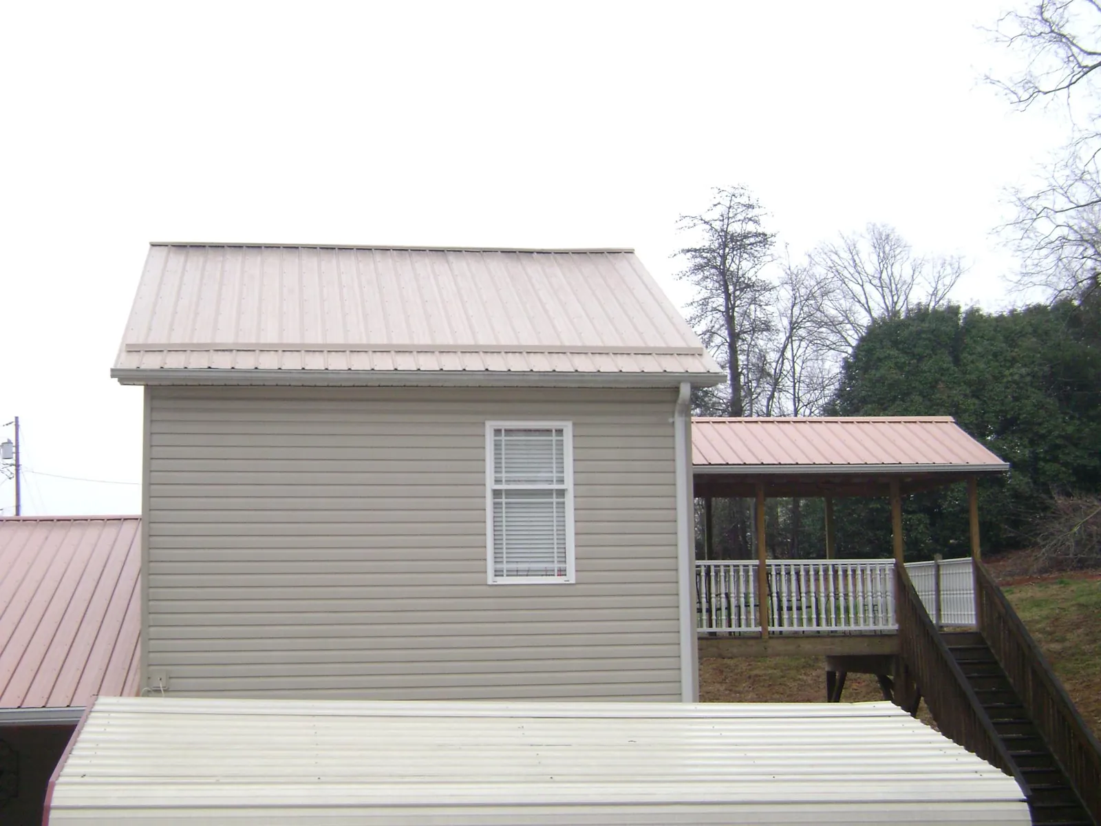 Tan metal roofs on a two story addition and attached porch, from a Roof Replacement job in Suisun City